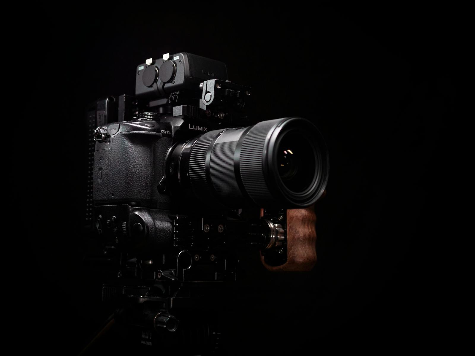 Close-up of a professional DSLR camera with a telephoto lens on a dark background.